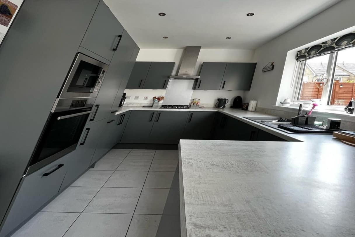 The same kitchen after respraying in a matt graphite, with new black bar handles
