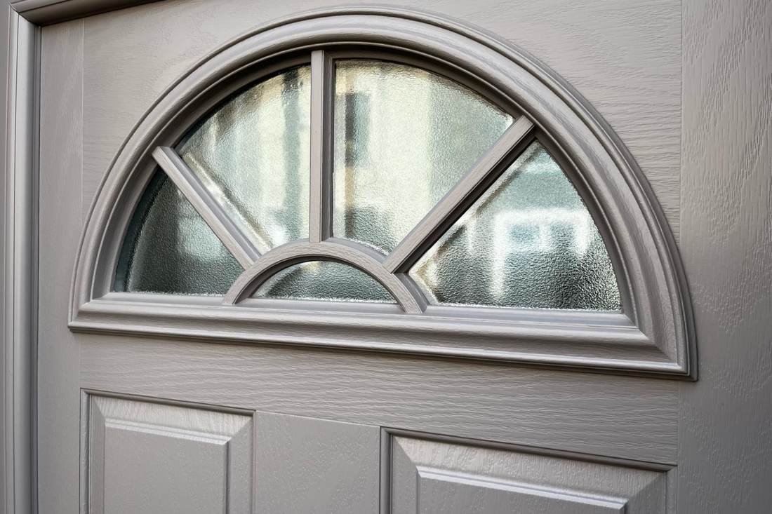 Close up of a grey composite front door after spraying